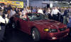 Dearborn Assembly Plant employee Fred Galicki drives the last vehicle built at the 86-year-old plant, a 2004 Ford Mustang GT, off the assembly line today. With him is retiree Oscar Hovsepian who drove the first Mustang off the same assembly line in 1964.